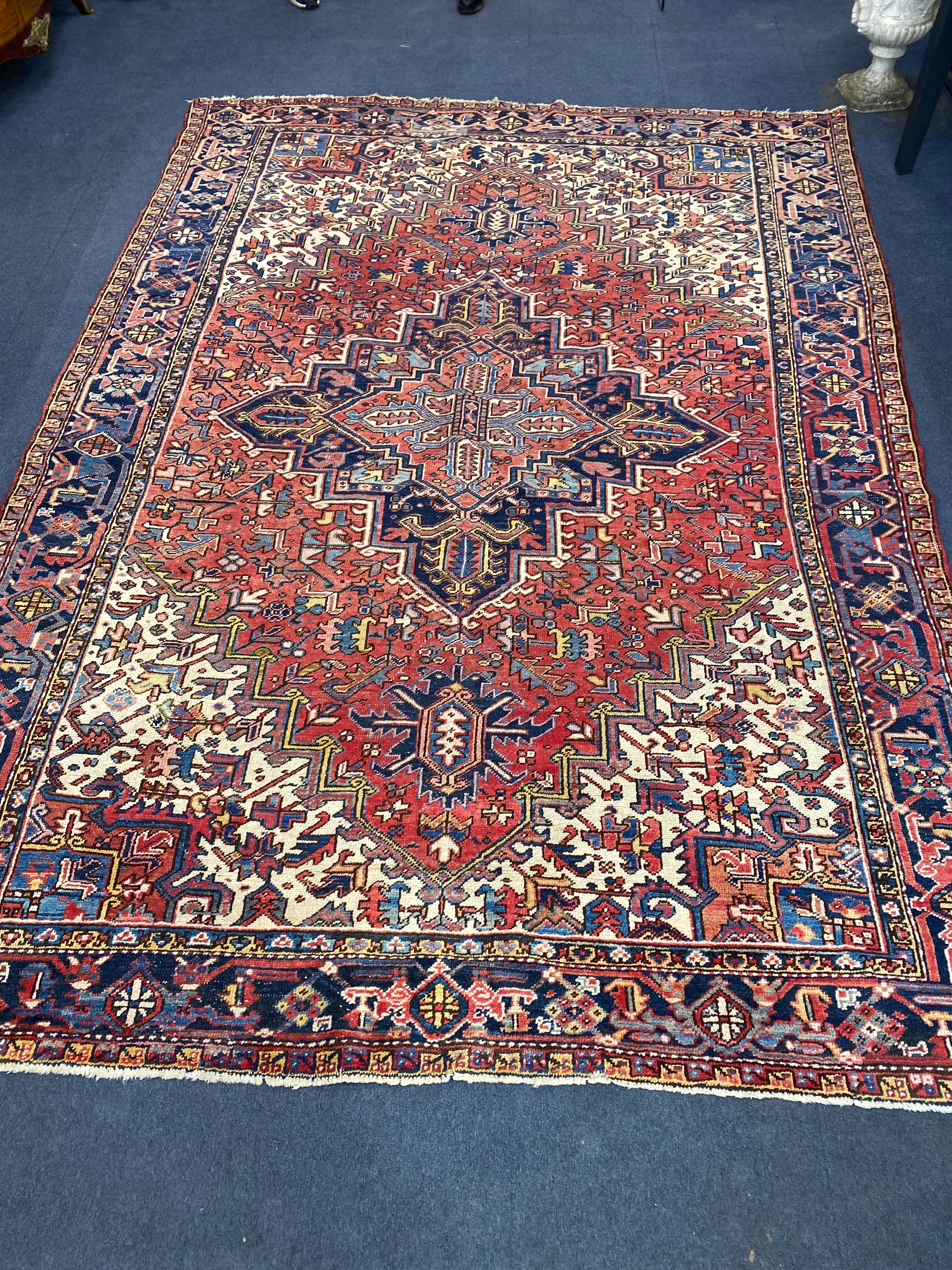 A Heriz brick red ground carpet, 326 x 240cm